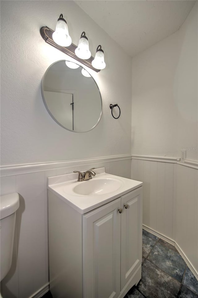 bathroom with toilet, tile floors, and vanity