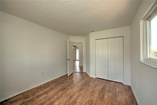 unfurnished bedroom with hardwood / wood-style flooring and a closet