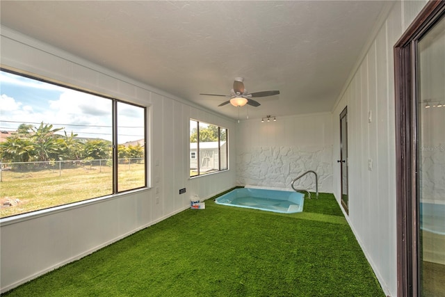 unfurnished sunroom featuring ceiling fan