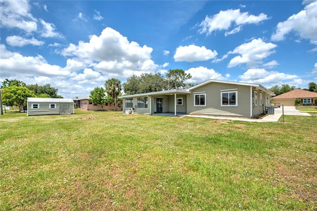 back of house with a yard and an outdoor structure