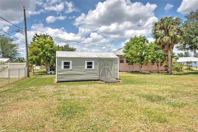 back of property featuring a yard and a storage shed