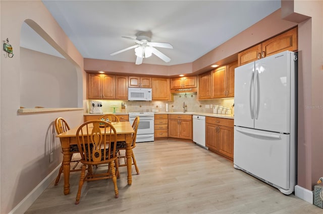 kitchen featuring ceiling fan, sink, tasteful backsplash, light hardwood / wood-style flooring, and white appliances