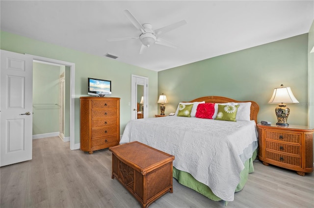 bedroom featuring light hardwood / wood-style floors, ensuite bath, and ceiling fan