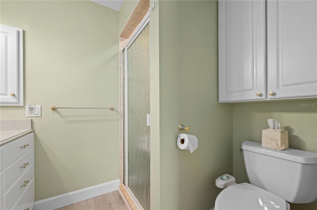 bathroom with vanity, hardwood / wood-style flooring, toilet, and a shower with shower door