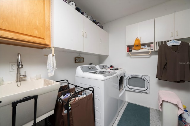 laundry area featuring washer and clothes dryer, cabinets, and sink