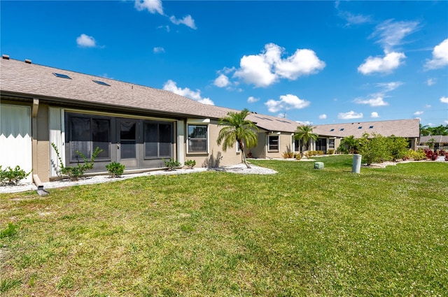 rear view of property featuring a lawn