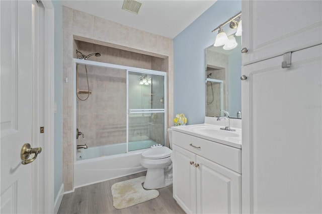 full bathroom featuring hardwood / wood-style floors, vanity, toilet, and enclosed tub / shower combo