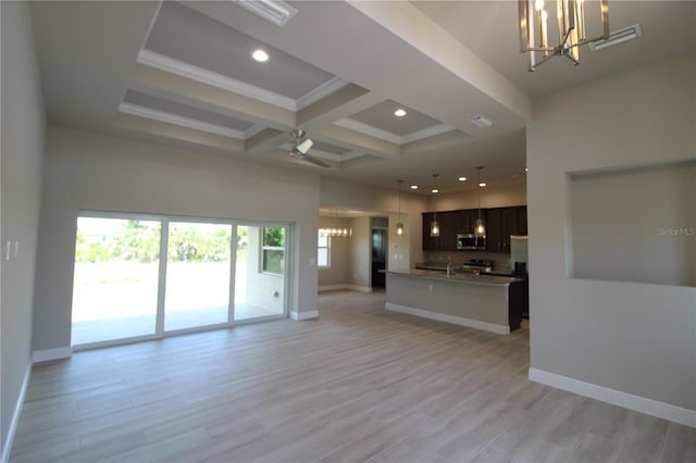 unfurnished living room with ceiling fan with notable chandelier, coffered ceiling, light hardwood / wood-style flooring, and beamed ceiling