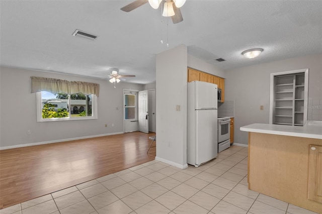 kitchen featuring a textured ceiling, white appliances, light hardwood / wood-style floors, and ceiling fan