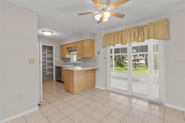 kitchen with kitchen peninsula, tasteful backsplash, stainless steel dishwasher, ceiling fan, and light brown cabinets