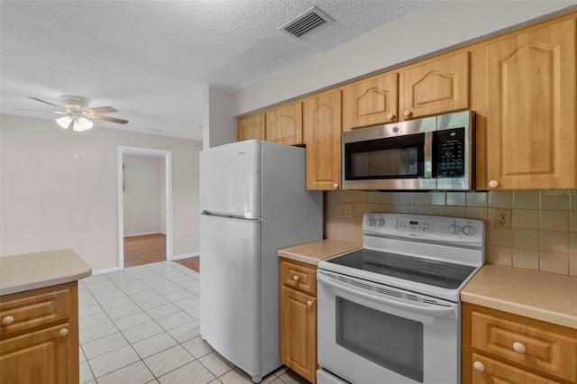 kitchen featuring tasteful backsplash, a textured ceiling, white appliances, ceiling fan, and light tile patterned flooring