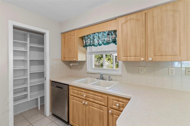 kitchen with tasteful backsplash, a textured ceiling, sink, light tile patterned floors, and dishwasher