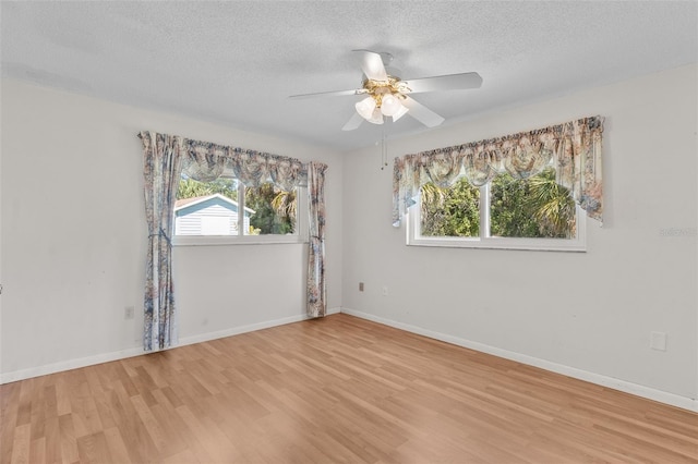 empty room with ceiling fan, a textured ceiling, and light wood-type flooring