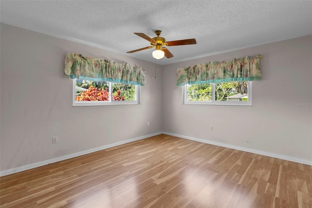 unfurnished room with hardwood / wood-style flooring, ceiling fan, and a textured ceiling