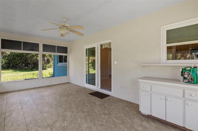 unfurnished sunroom featuring ceiling fan