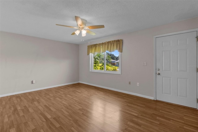 unfurnished room with ceiling fan, a textured ceiling, and hardwood / wood-style flooring