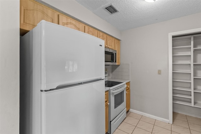 kitchen with light brown cabinets, white appliances, backsplash, light tile patterned floors, and a textured ceiling