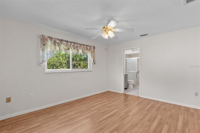 spare room with a textured ceiling, light hardwood / wood-style flooring, and ceiling fan