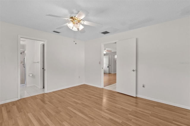 spare room with ceiling fan, a textured ceiling, and light hardwood / wood-style flooring