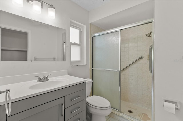 bathroom featuring toilet, an enclosed shower, and vanity