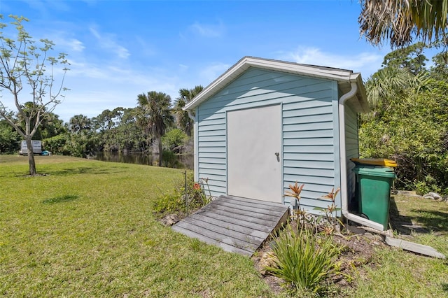 view of outbuilding featuring a lawn and a water view