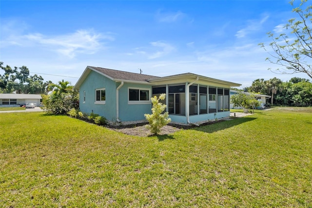 back of house featuring a yard and a sunroom