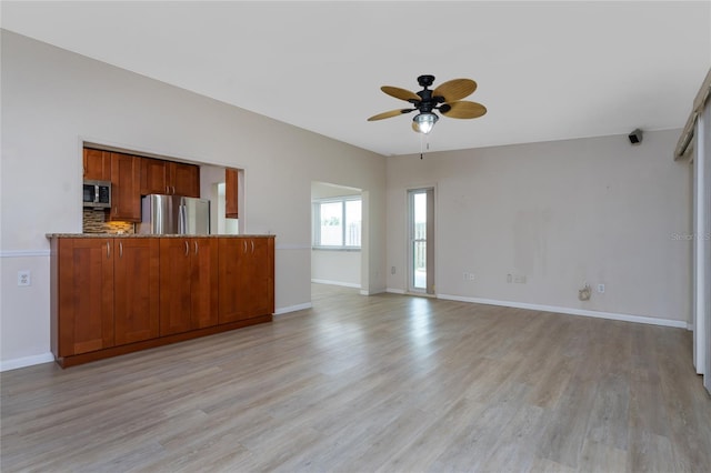 unfurnished living room with ceiling fan and light wood-type flooring