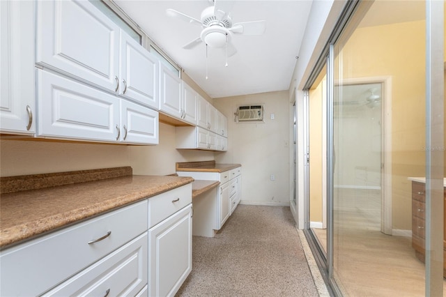 kitchen featuring white cabinetry, a wall mounted air conditioner, and ceiling fan