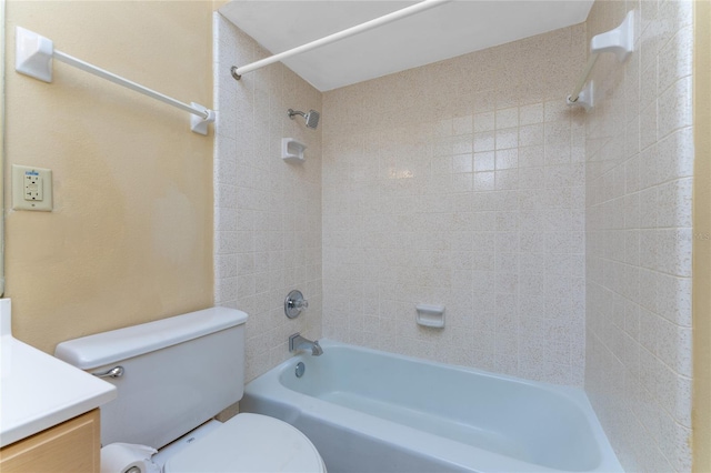 full bathroom featuring vanity, tiled shower / bath, and toilet