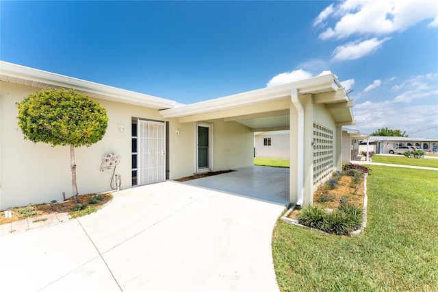 entrance to property with a yard and a carport