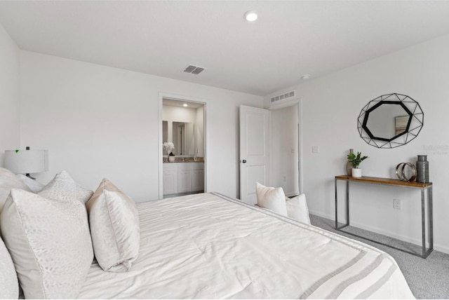 bedroom featuring connected bathroom and light carpet