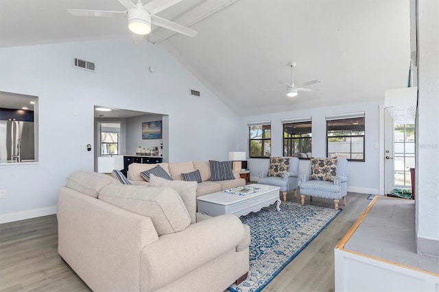 living room with beam ceiling, hardwood / wood-style flooring, high vaulted ceiling, and ceiling fan