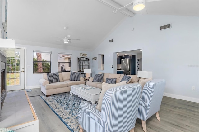 living room with beamed ceiling, hardwood / wood-style floors, high vaulted ceiling, and ceiling fan