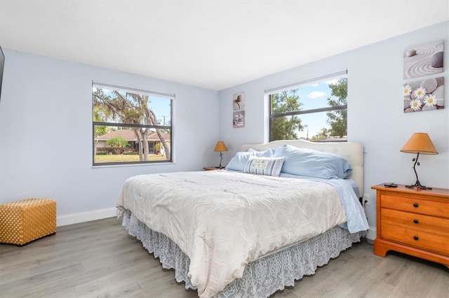 bedroom with hardwood / wood-style flooring and multiple windows