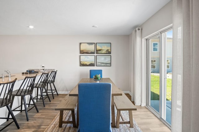 dining area with wood-type flooring and sink