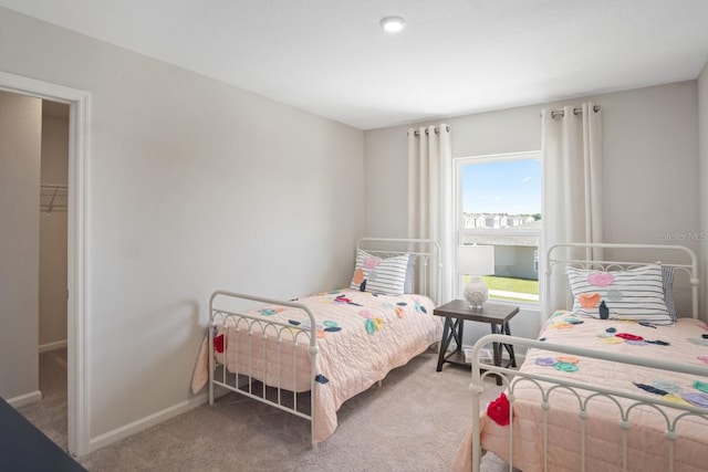 bedroom with carpet, a closet, and a walk in closet