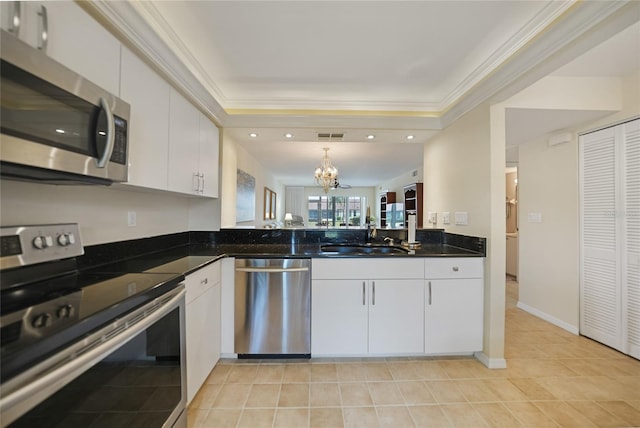 kitchen featuring appliances with stainless steel finishes, hanging light fixtures, light tile flooring, white cabinetry, and sink