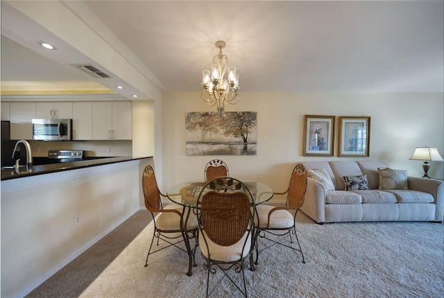 dining space with an inviting chandelier, light carpet, and sink