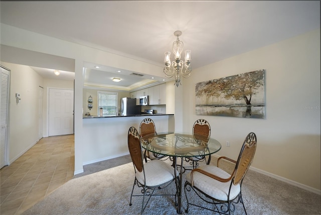 tiled dining space featuring a notable chandelier and a tray ceiling