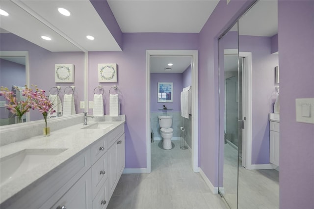 bathroom featuring tile flooring, toilet, double sink, and large vanity