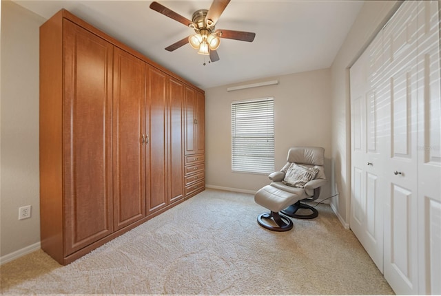 sitting room featuring light colored carpet and ceiling fan