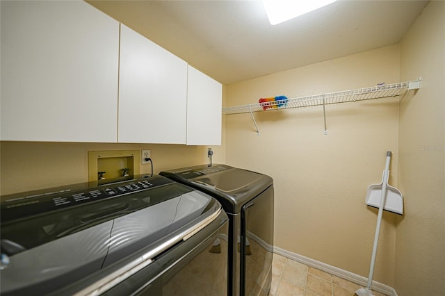 clothes washing area featuring hookup for a washing machine, cabinets, light tile floors, and washer and dryer