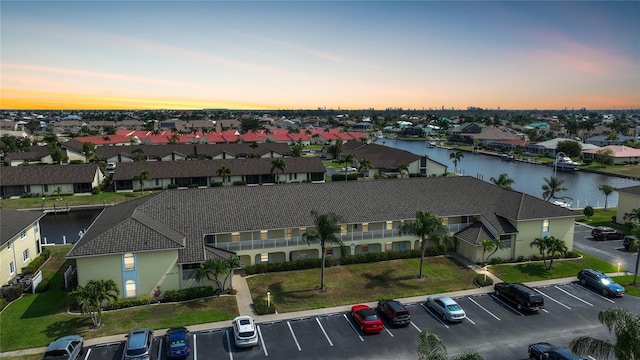 aerial view at dusk featuring a water view