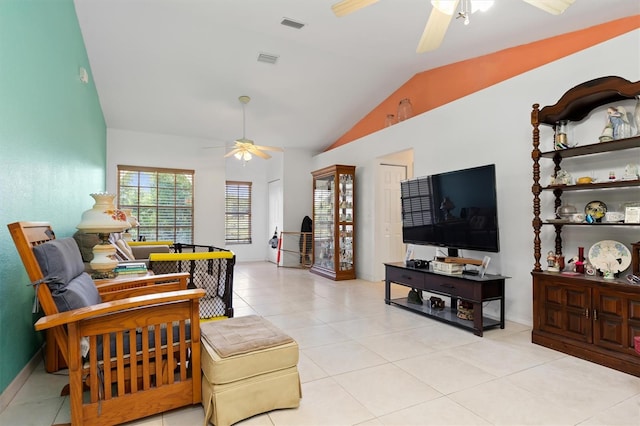 living room with lofted ceiling, ceiling fan, and light tile floors