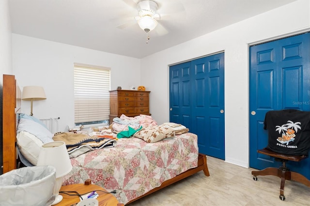 bedroom with multiple closets and ceiling fan