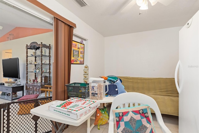 bedroom featuring white refrigerator, tile flooring, ceiling fan, and lofted ceiling