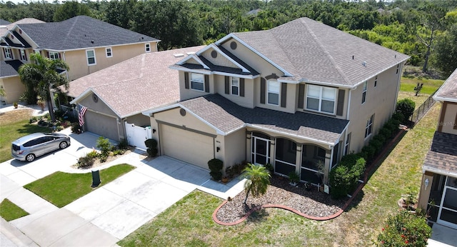 view of front of house with roof with shingles, an attached garage, and stucco siding