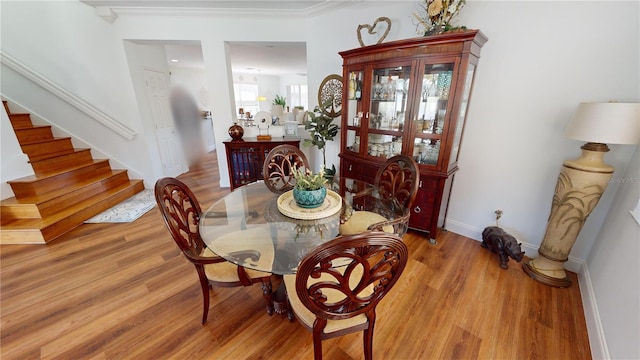 dining area featuring light wood-type flooring and ornamental molding