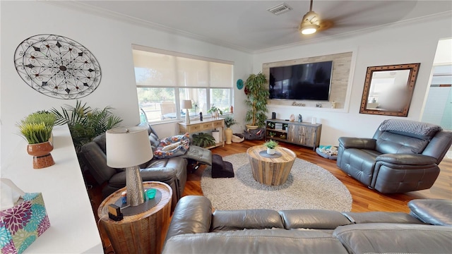 living room featuring hardwood / wood-style floors, ceiling fan, and ornamental molding