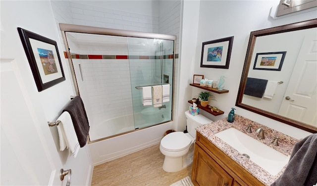 full bathroom featuring toilet, combined bath / shower with glass door, and vanity